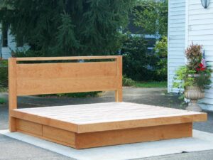 Platform bed with 4 drawers and headboard with top bar front view