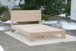 sturdy platform bed with angled headboard and wide thick posts side view