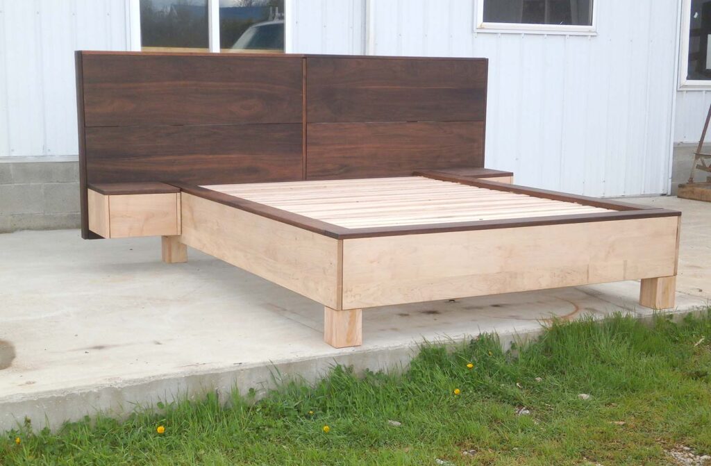 side view of a platform bed with large headboard and attached side tables