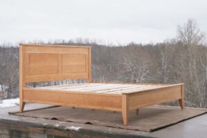 Platform Bed with paneled headboard and tapered posts side view