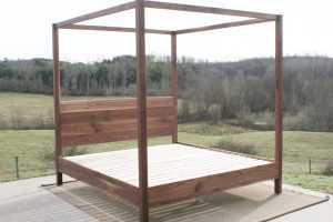 angled front view walnut canopy bed with square rails