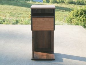 Overhanging table with drawer, shelf and support bar front view